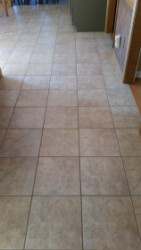 New Tile A tiled floor with light beige square tiles, arranged in a grid pattern.